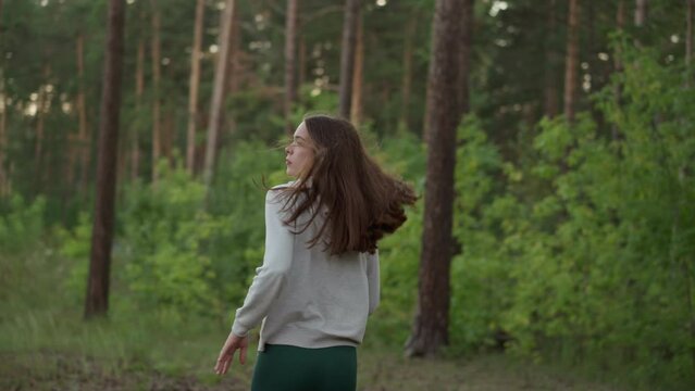 Female athlete runs through dense woods