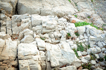 Texture of mountain rock on a sunny day, background. Lines and spots. Antibes, France