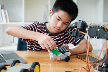 Asian teenager doing robot project in science classroom. technology of robotics programing and STEM...
