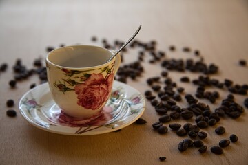 cup of hot coffee with coffee beans in the background