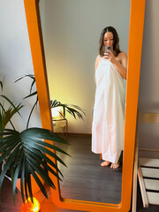 Selphie picture in mirror. Girl at SPA centre. Preparing for massage. Body therapy. Korean girl taking picture of herself in bedroom wearing bedsheet. Film grain texture. Soft focus. Blur - obrazy, fototapety, plakaty
