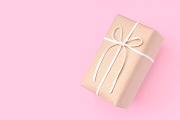 Gift box with natural taste decorated with white strings on a pink background