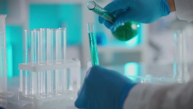 Scientific research in the field of microbiology is carried out in specialized laboratory. A microbiologist carefully pours liquid into test tubes and flasks, sequentially mixing chemical compositions