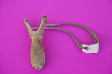 Handmade wooden slingshot, a Y-shaped stick with elastic between the arms; used to propel small stones Thai traditional weapon that use to shoot birds, fish , for fight game or other purposes.        