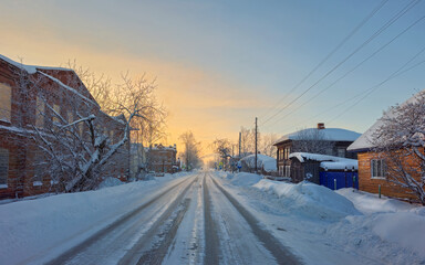 Winter village of Cherdyn. Winter road through a snow-covered village, severe frost, snow haze. Perm Region, Russia.