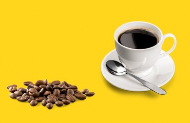 Black coffee cup with beans in steel spoon and yellow background