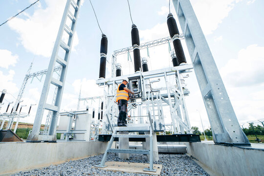 Adult electrical engineer inspect the electrical systems at the equipment control cabinet. Installation of modern electrical station