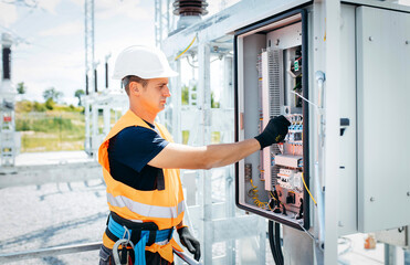 Adult electrical engineer inspect the electrical systems at the equipment control cabinet....