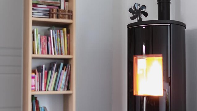 Timelapse of a pellet stove in a living room with bookcase and heat diffuser