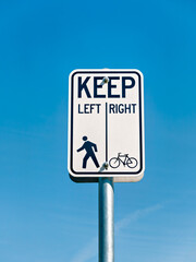 Bicycle and pedestrian shared route sign on clear sky background