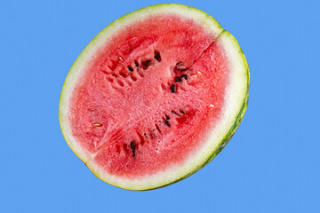 Half of a juicy watermelon on a blue background. A piece of watermelon isolated on a blue...