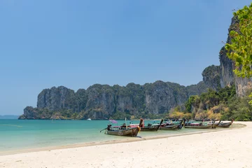 Photo sur Plexiglas Railay Beach, Krabi, Thaïlande Krabi, Thailand - March 18, 2021: Wooden traditional boat at Railay Beach with crystal clear water, famous tourist destination and resort area in Southern of Thailand.