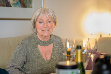 Older lady sitting on the couch and looking directly into the camera