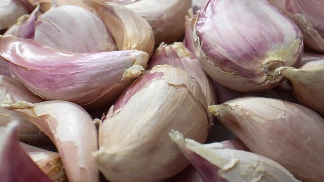 Uncover the hidden artistry of garlic bulbs. Marvel at the minute intricacies, as this macro video reveals the organic beauty concealed within each clove. Food stock footage.
