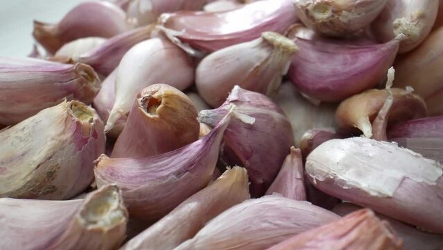 A captivating macro video, garlics become a universe of their own. Marvel at the graceful curves, the play of light, and the sensual allure of these culinary gems. Food stock footage. 4K.
