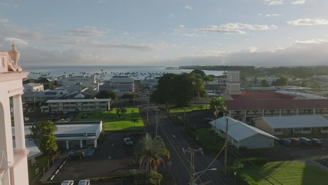 sunrise view of Hilo Hawaii flying backwards past church tower