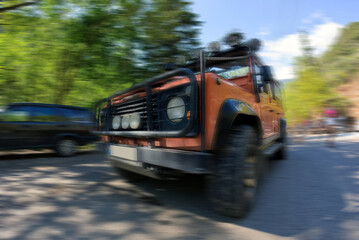 Fototapeta na wymiar An offroad jeep in motion blurred on a road, Sports utility vehicle for adventure