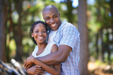 Hug, portrait or black couple hiking in forest to relax or bond on holiday vacation together in...