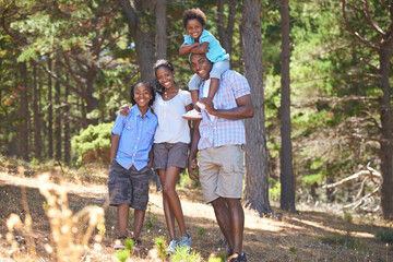 Smile, portrait or black family hiking in forest to relax or bond on holiday vacation together in nature. Children siblings, mother or happy African father in woods trekking on fun outdoor adventure