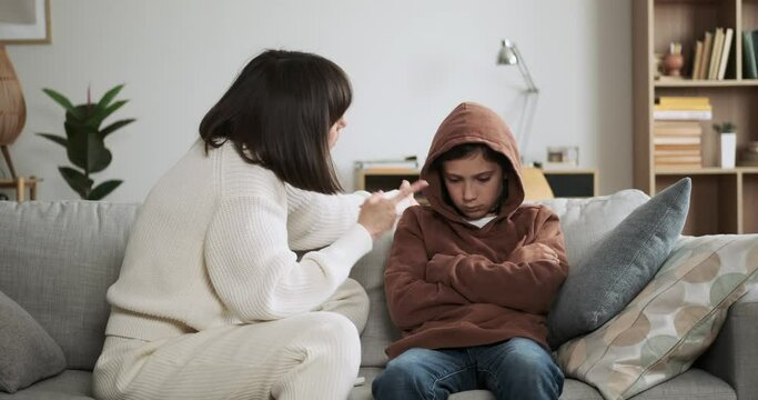 Upset mother expresses frustration while scolding son. The emotional tension in the room is evident as she imparts her feelings and concerns, highlighting a difficult moment of communication.