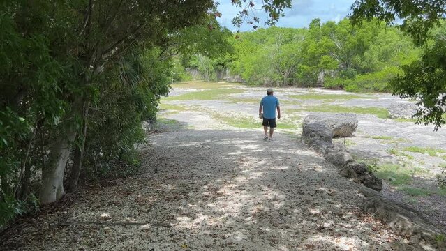A man walking in the fossil area at Windley Key Fossil Reef Geological State Park in Islamorada, Florida.