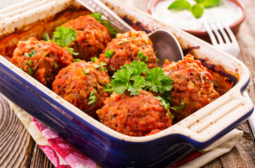 Traditional Persian slow cooked koofteh nokhod-chi meatballs with yoghurt served as close-up in a backing pan