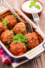Traditional Persian slow cooked koofteh nokhod-chi meatballs with yoghurt served as close-up in a backing pan