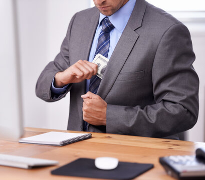 Business man, money laundering and pocket for corporate crime, stealing or fraud in accounting at his office desk. Person or criminal hands hiding cash for investment secret, bribery and corruption