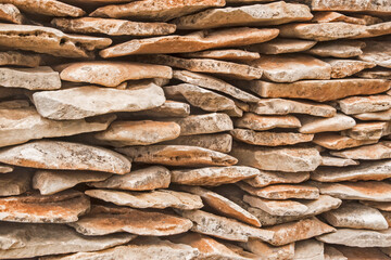 Stone wall made of stone slabs closeup as background