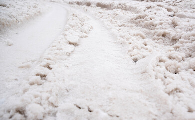 Tracks from a passing car, on the snow. A car drove through the white snow