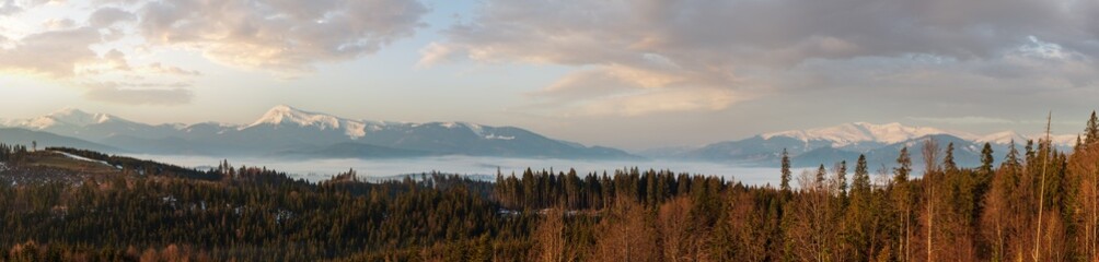 Spring dusk Carpathian mountains landscape with snow-covered ridges in far, Ukraine. From left to...