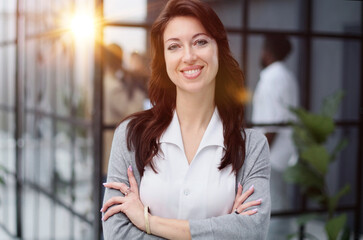 Confident young woman in a closed pose. Office professions