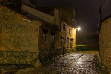 Cobblestone street, houses and wall in the town of Urueña at night. Valladolid, Castilla y León, Spain.