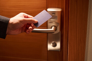 Cropped photo of man hand unlocking door with keycard