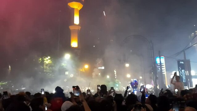 Fireworks festival event celebration at night, exploding fireworks sparkling in the sky, People immortalize moment by recording videos using smartphones. Suitable for carnival, fireworks, new year etc