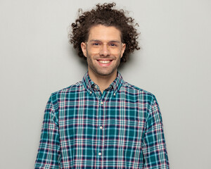 handsome curly hair man with glasses in checkered shirt smiling