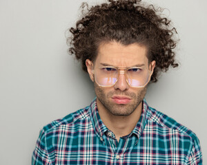 attractive young man with glasses looking forward and making a cute upset face