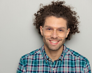 close up picture of happy man with curly hair wearing glasses and smiling