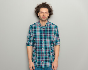 portrait of handsome casual man with glasses and plaid shirt looking forward