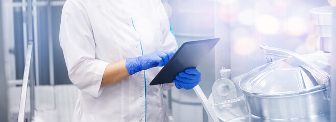 Concept food quality industrial banner. Factory worker with computer tablet inspecting production...