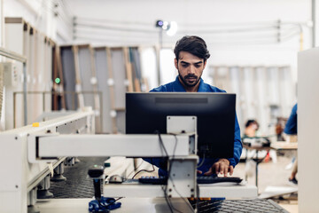 Carpenter working on woodworking machines in carpentry shop. Carpenter working to making wood...