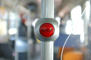 A button for pressing the stop button on a bus. It is a red button with black font , attached to a pole.