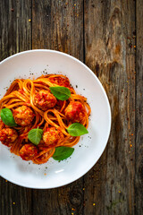Spaghetti meatballs in bolognese sauce on wooden table