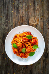 Spaghetti meatballs in bolognese sauce on wooden table