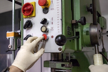 The worker operator of a mechanically controlled drilling machine performs work.
