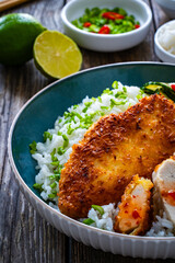 Tonkatsu - crispy Japanese pork chop with white rice and  fresh vegetables on wooden table