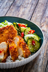 Tonkatsu - crispy Japanese pork chop with white rice and  fresh vegetables on wooden table