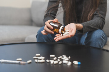Anti drugs, drug addict, asian young woman hand pour, holding bulk medicine out of pills bottle on...