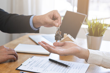 Close up agent giving a key to new owner or tenant, client after signed signature contract rental...