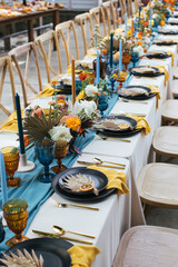 Party table decorated with centerpieces, flowers and vibrant silverware.